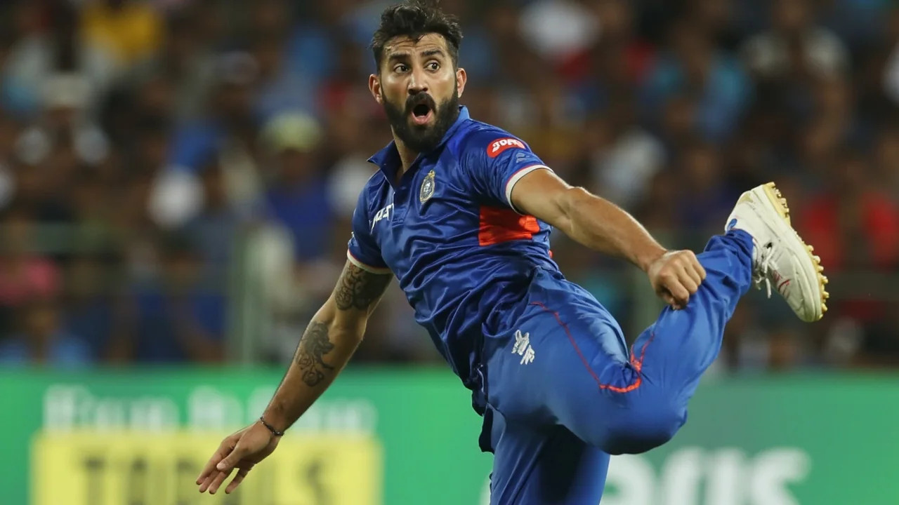 Tight sideline action frame of a right-arm off-spinner at the point of delivery during a domestic Indian first-class match